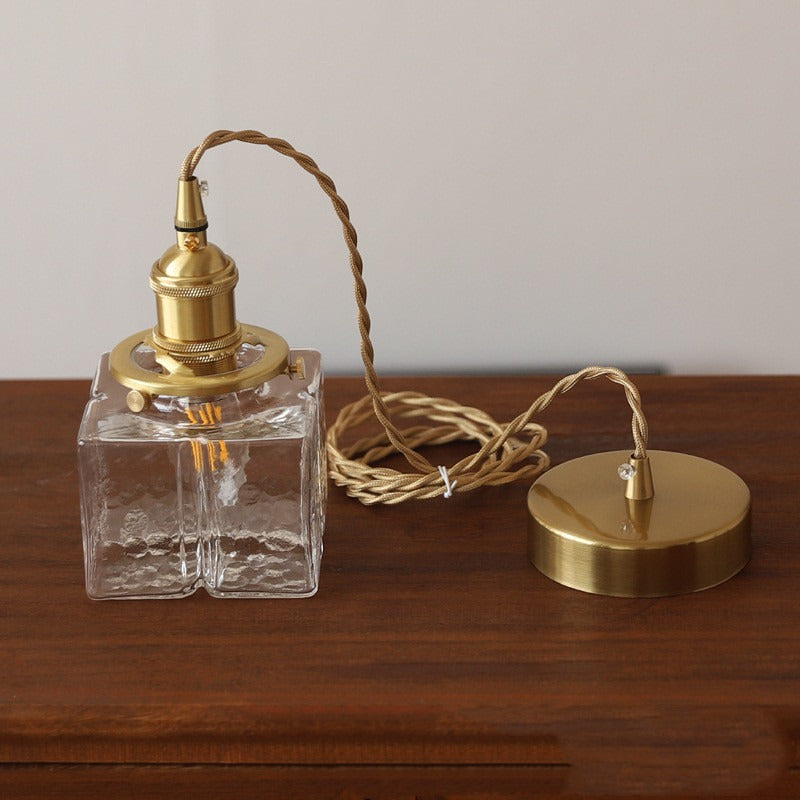 Clear glass lamp with gold metal components on a wooden surface