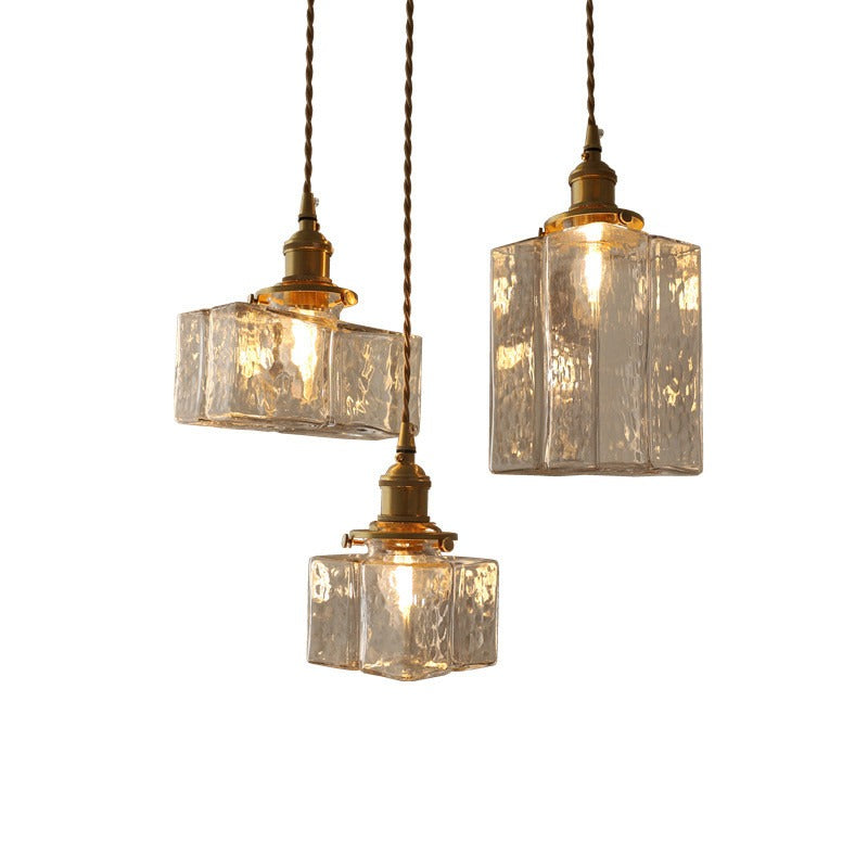 Three hanging pendant lights with glass shades on a white background